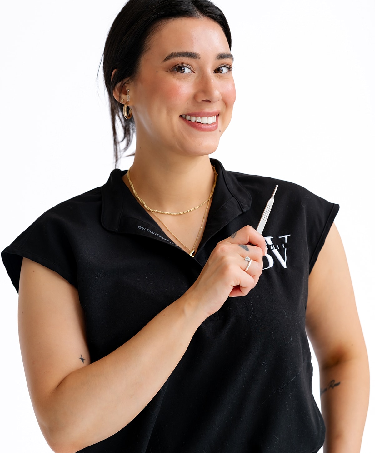 Smiling woman holding a tool in black shirt.