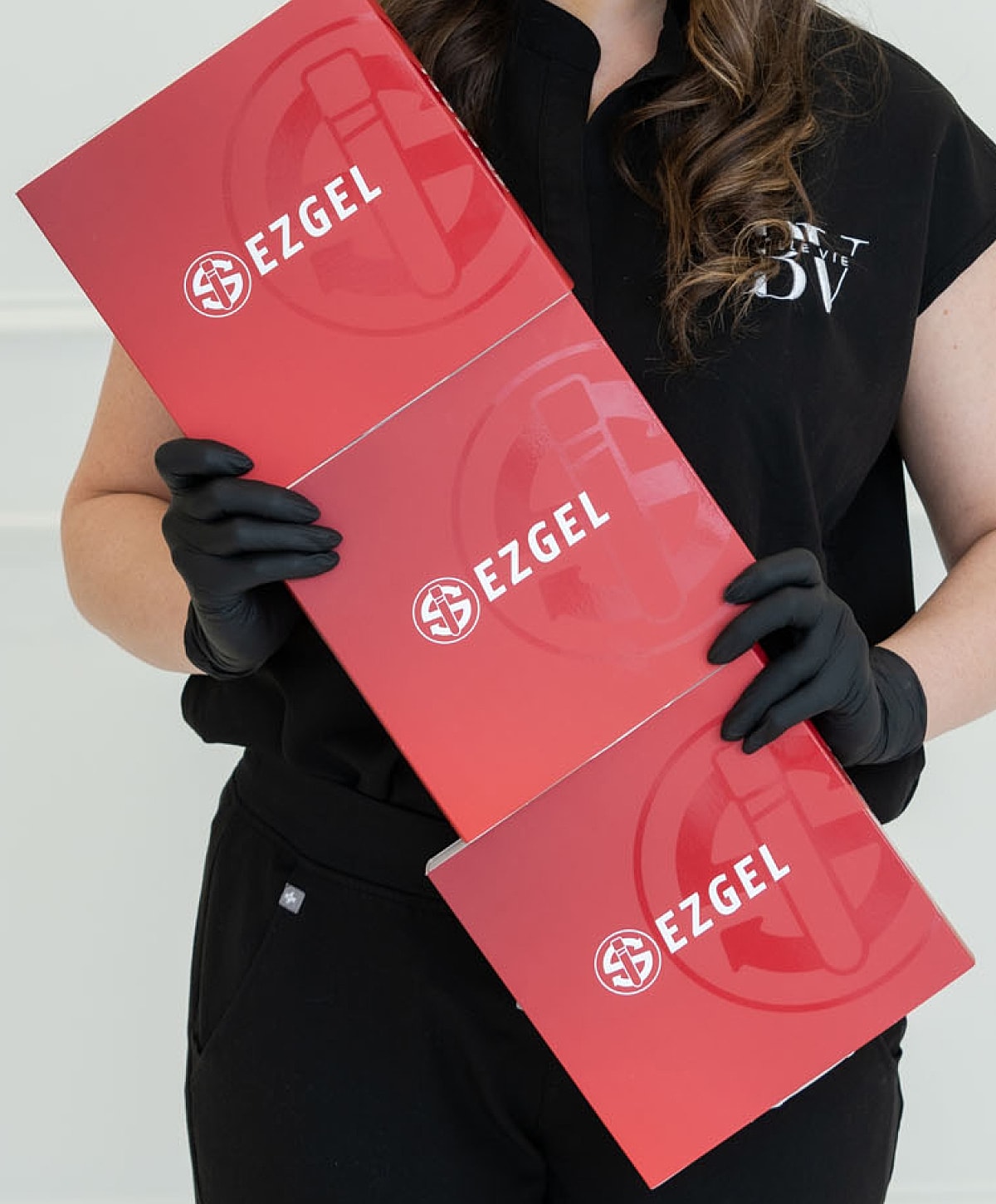 Person holding EZGEL boxes while wearing gloves