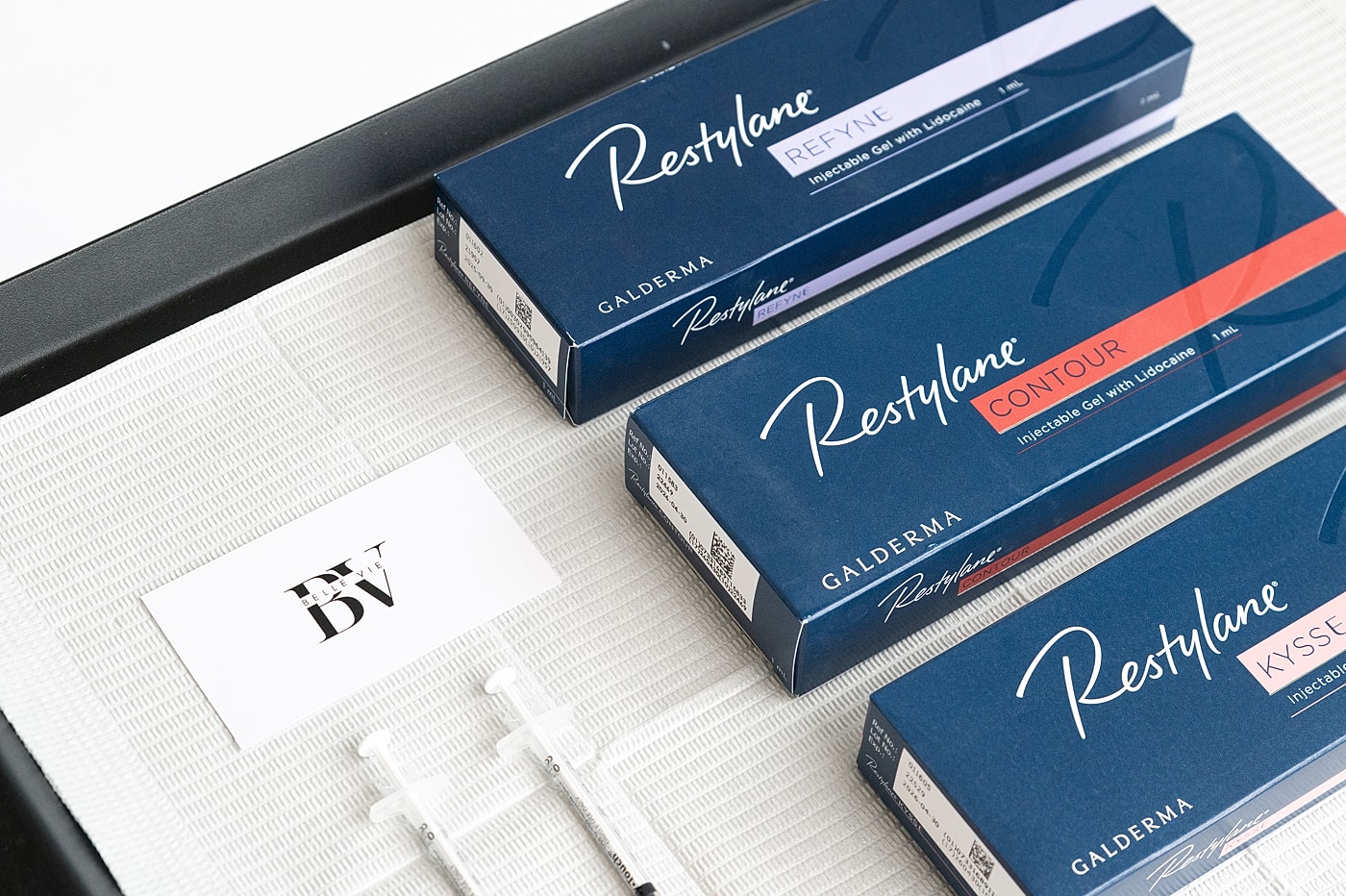 Cosmetic products displayed on a marble surface.