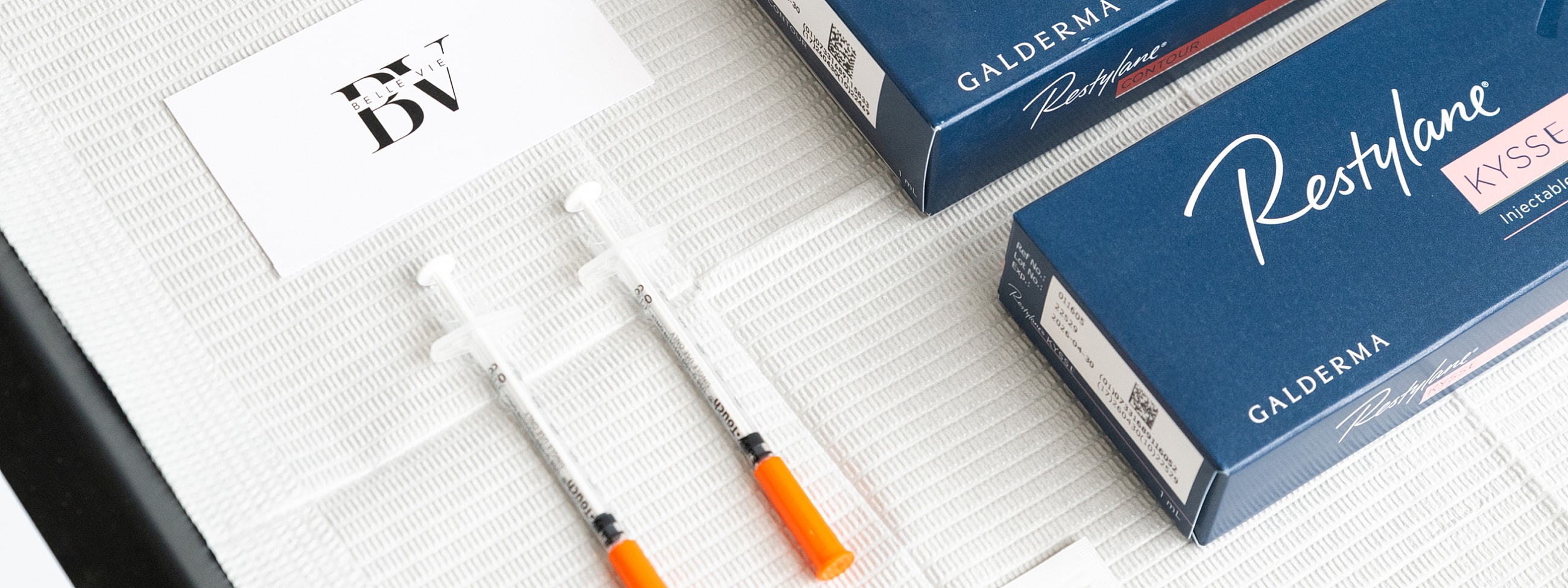Syringes and Restylane boxes on a table.